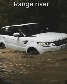 a range rover is driving through a flooded river