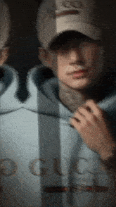 a blurry picture of a man wearing a hat and a gucci hoodie