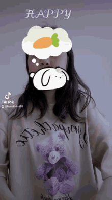 a girl with a purple teddy bear on her shirt has a thought bubble with a carrot in it