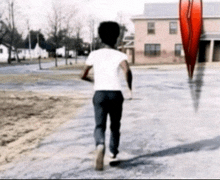 a person walking down a street with a red object in the background