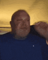 a man in a blue shirt is talking on a phone