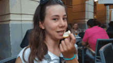 a girl with a blue bracelet on her wrist eating something