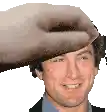a close up of a man 's face with a hand on his head .