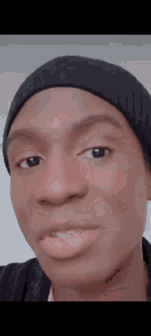 a close up of a person 's face with a beanie on .