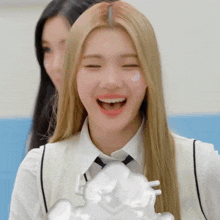 a girl with long blonde hair and a white shirt and tie is smiling
