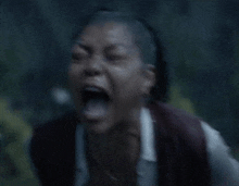 a woman with a shaved head is screaming with her mouth open in the rain .
