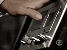 a close up of a person 's hand pressing a button on a radio .