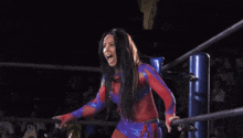 a woman in a wrestling ring with a sign that says bullet club in the background