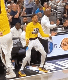 a basketball player wearing a yellow shirt that says yes cera