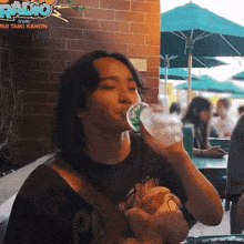 a man drinking water from a bottle with the words radio from rui taiki kanon on the bottom