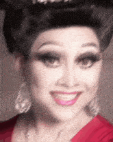 a close up of a woman 's face wearing a red dress and silver earrings
