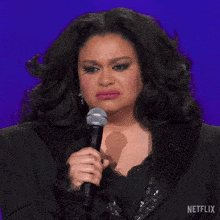 a woman is holding a microphone with a netflix logo in the corner