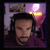 a man with a beard is wearing headphones and a purple shirt .