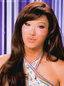 a woman wearing a louis vuitton scarf around her neck makes a funny face