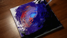 a painting is being painted on a wooden surface with a brush