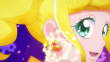 a close up of a girl 's face with yellow hair and green eyes