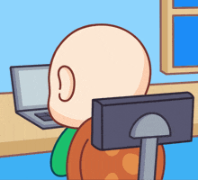 a bald man is sitting in front of a computer monitor