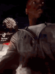 a man is standing in front of a fireworks display and looking up .