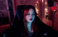 a woman is sitting in a chair in front of a microphone in a dark room .