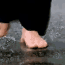 a person is walking through a puddle of water with their feet in the water .