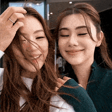 a woman with a ring on her finger looks at another woman 's face