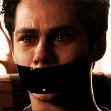 a close up of a man 's face with duct tape on his mouth