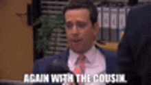 a man in a suit and tie is talking to another man in a room .
