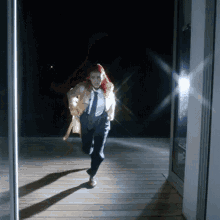 a woman in a yellow coat and tie is running in the dark