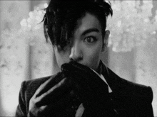 a black and white photo of a man covering his face