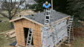 a man on a ladder working on the roof of a shed with a ladder that says ' gator '