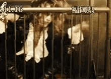 a woman is standing in a cage with a time of 11:16 on the bottom of the screen .