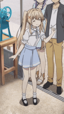a girl in a blue skirt is standing next to a man and another girl