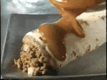 a close up of a piece of cheesecake with caramel being poured on it