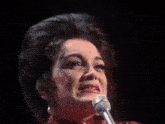 a woman singing into a microphone on a stage