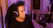 a man wearing headphones sits in front of a microphone