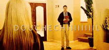 a man holding a folder stands in a room with the words douchechiiii written on the bottom