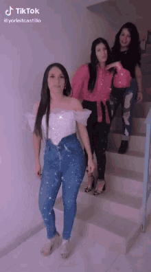 three women are standing on a set of stairs with a tik tok watermark