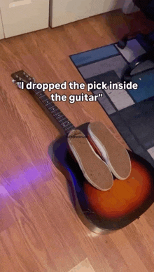 a guitar with the words " i dropped the pick inside the guitar " on the bottom