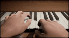 a close up of a person playing a piano with their hands on the keys