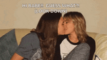 two women kissing on a couch with the words hi babe guess what look down below them