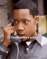 a young boy is talking on a cell phone and says `` i have planted a bomb '' .