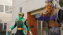 a man in a green and gold costume is standing next to a monster
