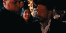 a man with a beard is standing in front of a crowd of people