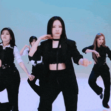 a woman in a black striped jacket is dancing with other women