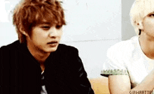 two men are sitting next to each other on a couch .