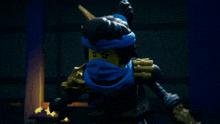 a lego figure with a blue scarf around his head holding a sword
