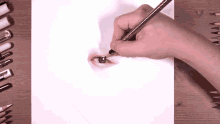 a person is drawing a woman 's eye on a piece of paper