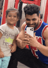a man taking a selfie with a little girl who is wearing a shirt that says " eyjbbo "
