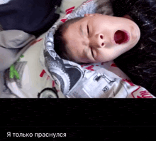 a young boy laying on a blanket with his mouth open and the words " я только проснулся " below him
