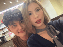a man and a woman are posing for a picture and the woman is wearing a choker
